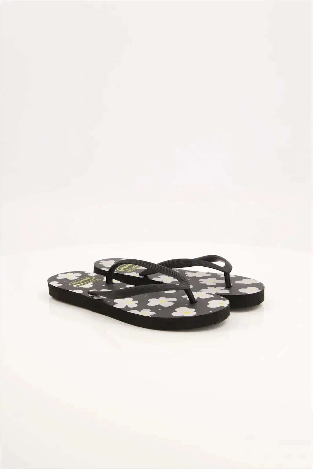 Street Feet's Flower Design Flip-Flops in black sole and white flowers, featuring soft soles and durable rubber straps for maximum comfort. Lightweight and breathable, ideal for casual wear.